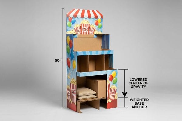 A 50-inch carnival cardboard display with popcorn graphics, showing sandbags for Lowered Center of Gravity and Weighted Base Anchor.