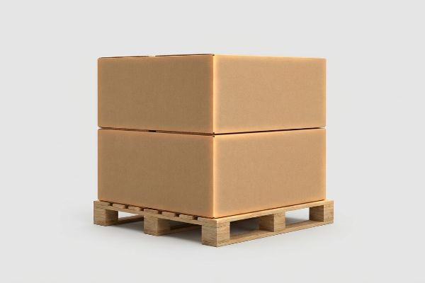 Two brown corrugated boxes stacked on a wooden pallet, showcasing proper zero-overhang to maintain compression strength and prevent collapse.