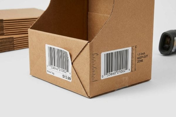 Affichage de la zone interdite par code-barres Boîte de présentation en carton ondulé comportant une étiquette de prix à code-barres de 13,99 $ et une étiquette indiquant une « zone interdite de 1,5 pouce » due à un pli structurel.