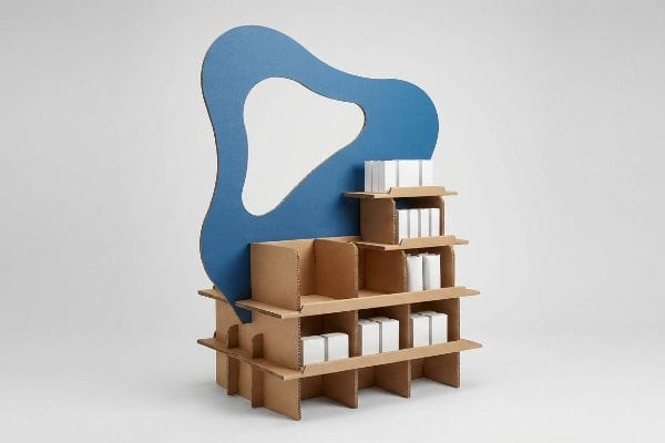 Modular Cardboard Display Stand Cardboard display stand with a blue die-cut header and modular shelves holding white product boxes.
