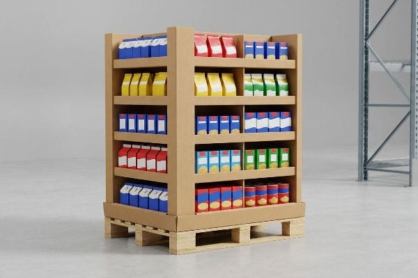 Cardboard point-of-purchase display on wooden pallets, showcasing diverse retail products in a warehouse.