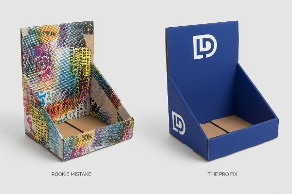 A corrugated display box with a chaotic, multi-layered CMYK halftone pattern, labeled Rookie Mistake, illustrating poor visual clarity.