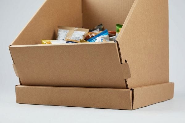 Cardboard Dump Bin Snacks An open-top brown corrugated cardboard dump bin filled with assorted packaged snacks for retail display.
