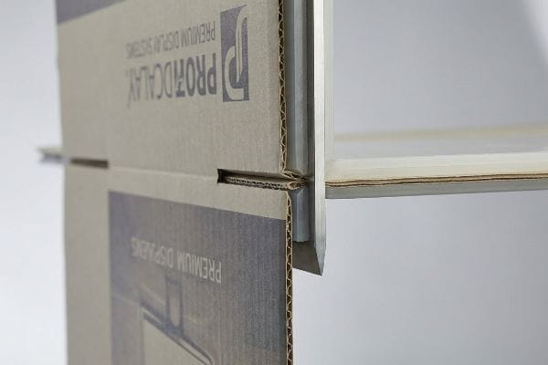 Corrugated cardboard display with a polymer creasing matrix reinforcing a structural fold, featuring Profocalay Premium Display Systems branding.