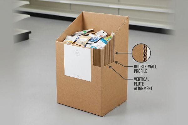 Brown corrugated dump bin with visible Double-Wall Profile and Vertical Flute Alignment, featuring a 'MINIMALIST' label and assorted packaged goods.