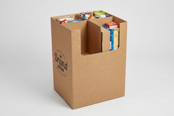 Collations en bac à déchets en carton ondulé Bac de rangement en carton ondulé brun avec séparateurs internes, rempli de produits de grignotage emballés, affichant un logo de marque.