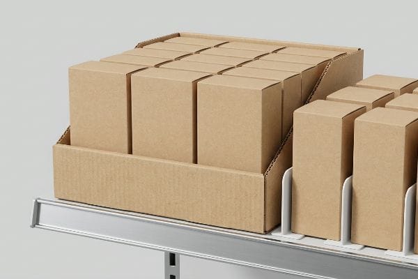 Multiple brown cardboard boxes arranged in a corrugated display tray and white modular dividers on a retail shelf, optimizing SKU organization.