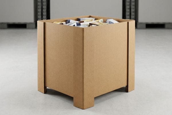 Corrugated open-top dump bin display, featuring vertical flute alignment, filled with packaged retail products on a warehouse floor.