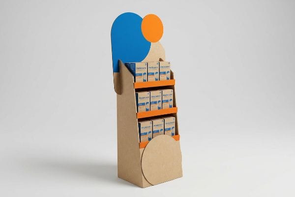 Cardboard POP Display Asymmetrical kraft cardboard POP display with orange shelves, blue header, and orange circle, featuring Denticare and Probiolife boxes.