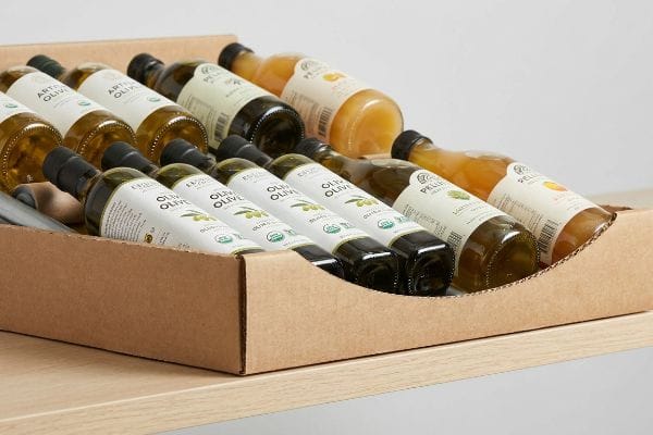Gravity Flow Rack Display Corrugated cardboard gravity flow rack with a die-cut swoop, displaying Espero Organic Olive Oil and Pellegrino bottles, ensuring 85% label visibility.
