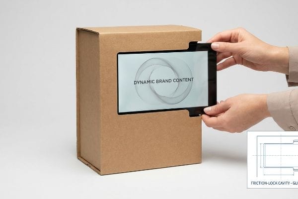Corrugated box with digital screen displaying Dynamic Brand Content, inserted by hands, showing Friction-Lock Cavity - GLI.