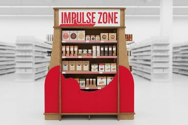 Corrugated cardboard end cap display featuring an "Impulse Zone" sign, red base, and shelves stocked with various packaged goods, designed for spatial disruption.