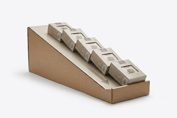 Brown corrugated cardboard gravity flow rack with six small kraft boxes sliding down a beige track, featuring a directional arrow.