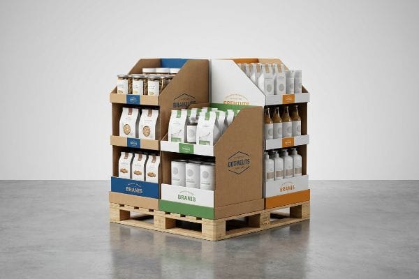 Kraft cardboard quarter pallet display on a wooden base, holding Branis, Gremtuts, and Dusheuts products in jars, bags, and bottles.