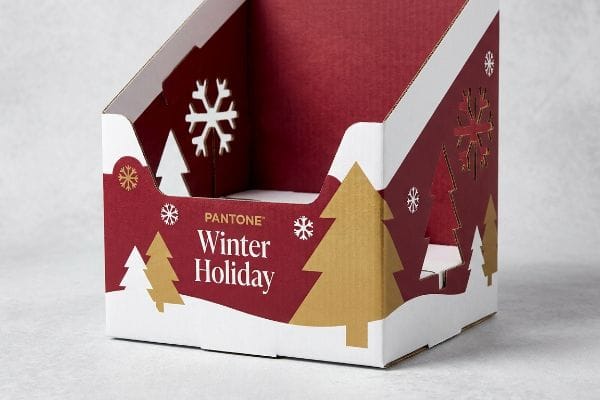 Pantone Winter Display Box A festive retail display box, branded Pantone Winter Holiday, features die-cut snowflakes and gold Christmas trees on red corrugated cardboard.