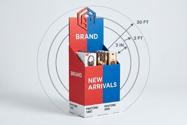 Two-tiered red Pantone 186C and blue Pantone 300C end cap display, featuring 'Brand' and 'New Arrivals' text. It highlights headphones, boxed products, and the 3-3-3 rule for retail engagement.