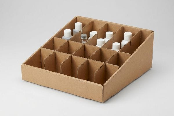 Cardboard PDQ Display Tray Brown corrugated cardboard retail-ready display tray with 24 compartments, holding small white and clear bottles, ideal for PDQ merchandising.