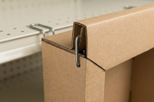 Corrugated cardboard display with a double-wall folded anchor reinforced by a metal S-clip on a retail gondola shelf, preventing shear force tearing.