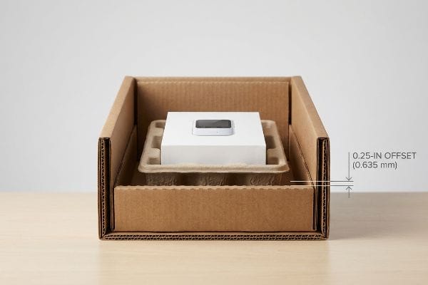 Packaging Offset Tolerance Corrugated cardboard box contains a molded pulp tray holding a white product box, illustrating a 0.25-inch Offset (0.635 mm) clearance.