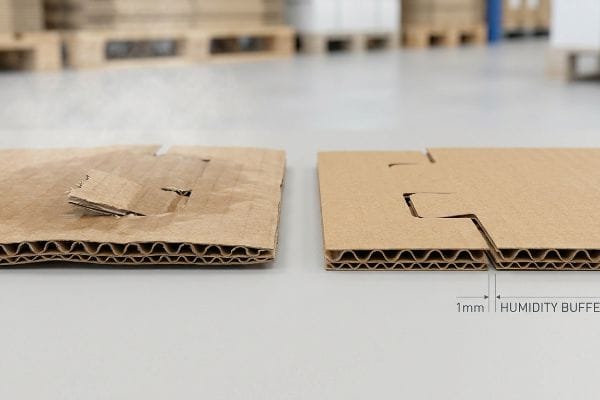Moisture-damaged corrugated cardboard with warped tabs and visible steam, contrasted with an intact piece featuring a 1mm Humidity Buffer.
