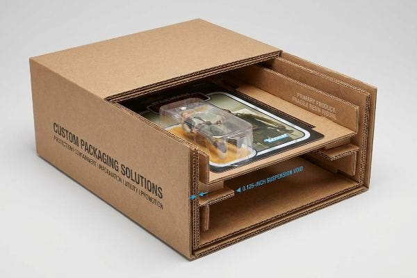 Brown corrugated box from Custom Packaging Solutions, suspending a Star Wars Kenner action figure, showing 0.125-inch Suspension Void for Fragile Resin Figure.