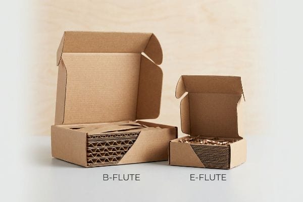 Bフルート Eフルート ボックス 開いた状態の2つの段ボール製メールボックス(BフルートとEフルート)は、それぞれ異なる内部構造と保護包装を示している。.