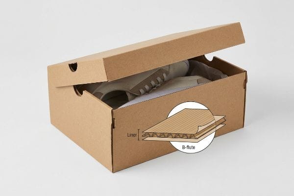 Brown corrugated shoe box with shoes, showing a B-flute and liner cross-section for structural integrity.