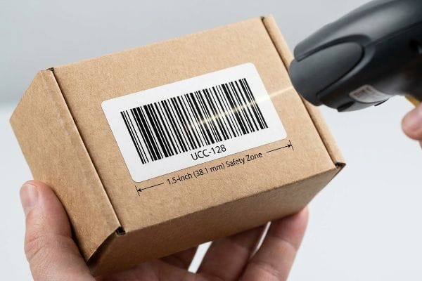 Barcode Scanning Safety Zone Brown corrugated box with a UCC-128 barcode label scanned, highlighting the 1.5-inch (38.1 mm) safety zone for logistics compliance.