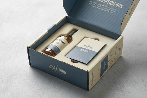 Buerbitood Subscription Box Open Buerbitood subscription box, beige and blue, with Buerbitood 12 bottle, Bourt booklet, custom insert, and "Description Box" on lid.