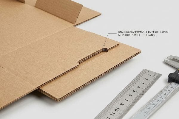 Humidity Buffer Cardboard Detail Corrugated cardboard box flap detail with text: Engineered Humidity Buffer (1.2mm) Moisture Swell Tolerance, alongside a ruler.