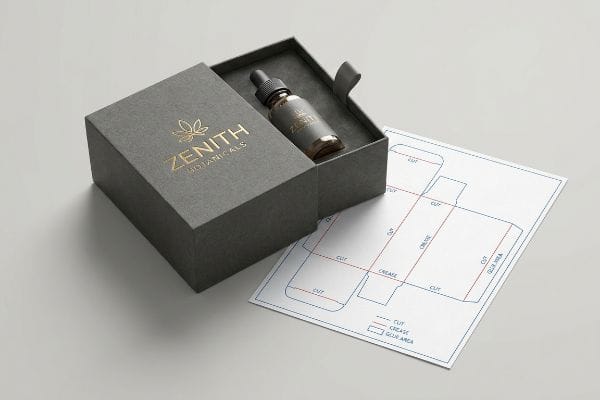 Zenith Botanicals Dieline An open dark grey CBD packaging box with gold foil Zenith Botanicals logo, containing a dropper bottle, next to a paper dieline template.