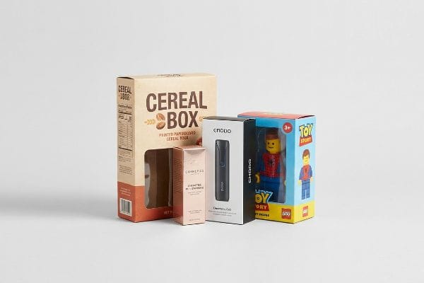 Folding Carton Product Assortment Four folding cartons: a kraft Cereal Box, rose gold Cosmetics, black Enano Choco electronics, and a blue Lego Toy Story figure box.