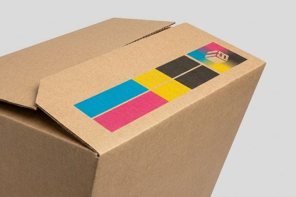 Lebendige CMYK-Verpackung Bedruckte CMYK-Farbbalken und ein stilisiertes Logo zieren einen braunen Wellpappkarton und unterstreichen die lebendige Verpackung.