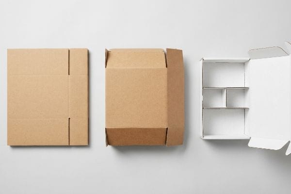 Mailer box types: flat kraft corrugated sheet, partially assembled brown box, and open white box with internal dividers.
