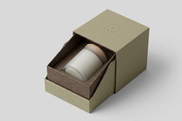 A frosted glass candle with a wooden lid is presented in an open, custom corrugated kraft box, showcasing sustainable packaging.