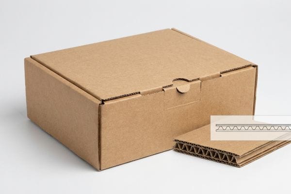 Corrugated Mailer Box Structure Displaying a brown corrugated cardboard mailer box with a visible cross-section of its fluted inner sheet and linerboards.