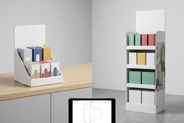 Cardboard Display Units Dieline White corrugated cardboard countertop display and floor display units, showcasing colorful product boxes, with a tablet displaying a packaging dieline.