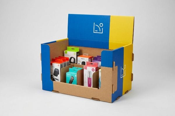 Retail Display Box Products Corrugated cardboard display box with blue and yellow sections, featuring a white line-art logo and modular dividers holding various small retail product boxes.