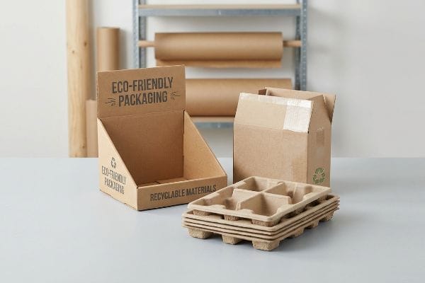 Eco-Friendly Packaging Solutions Corrugated display box with Eco-Friendly Packaging and Recyclable Materials text, alongside a shipping box and molded pulp inserts.