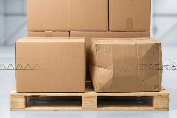 Corrugated Box Fatigue Brown virgin kraft and fatigued corrugated boxes on a pallet, showing internal flute structure for shock absorption.