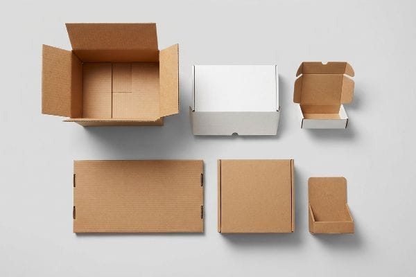 Display of diverse corrugated packaging styles: open mailer boxes, flat sheet, and point-of-purchase display.