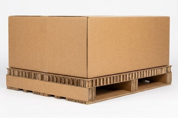 Brown corrugated cardboard box resting on an eco-friendly paper pallet, showcasing its fluting and stringer construction.