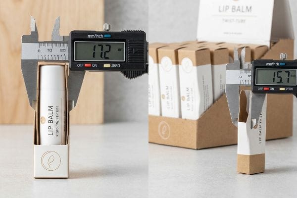 Lip Balm Tube Dimensions Digital calipers measure a Lip Balm Rigid Twist-Tube at 17.2 mm and an empty carton at 15.7 mm, illustrating cosmetic cylinder bulge.