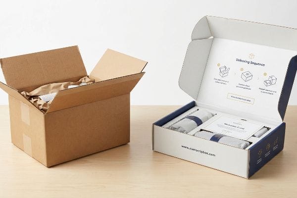 White Custscriptbox subscription box displaying 'Unboxing Sequence' and a 'Welcome Card', beside a brown shipping box.