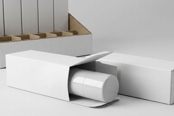 White folding carton revealing a glossy cylindrical container, alongside a closed carton and a cardboard display tray.