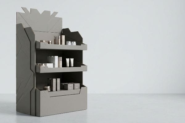 Die-Cut Cosmetic Display Grey multi-tiered POP display with aggressive die-cut design, showcasing cosmetic products for retail spatial engagement.