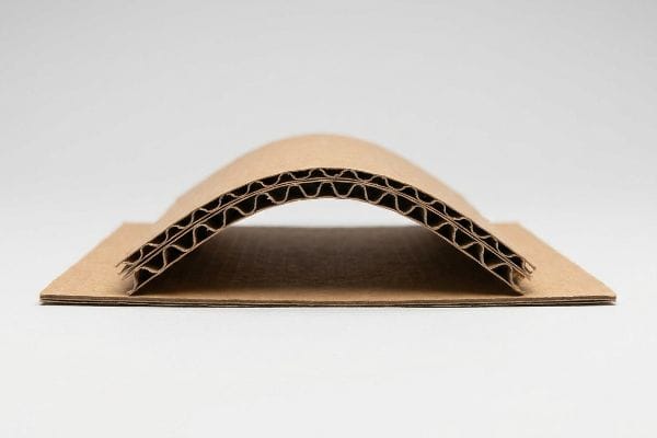 Corrugated Cardboard Flute Structure A close-up view reveals the arched structure of double-wall corrugated cardboard, showcasing its two fluted paper sheets between flat brown linerboards.