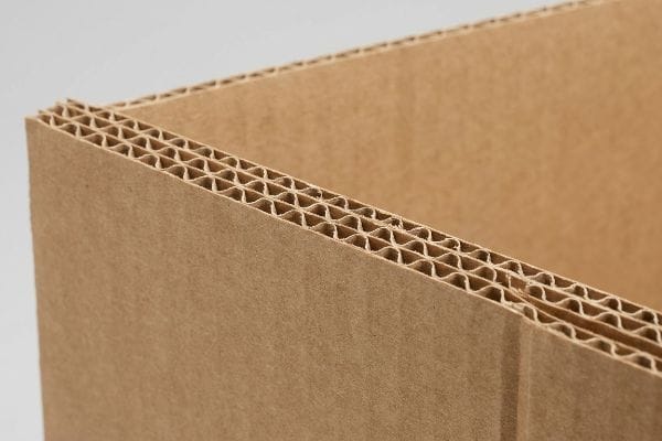 Close-up of double-wall corrugated cardboard edge, revealing the intricate micro-fluted geometry for packaging strength.