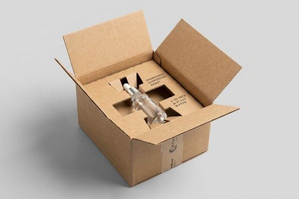 Suspension Insert Box Packaging An open corrugated shipping box reveals an Engineered Suspension Insert protecting a glass dropper bottle with a 0.125-inch (3.17 mm) buffer.