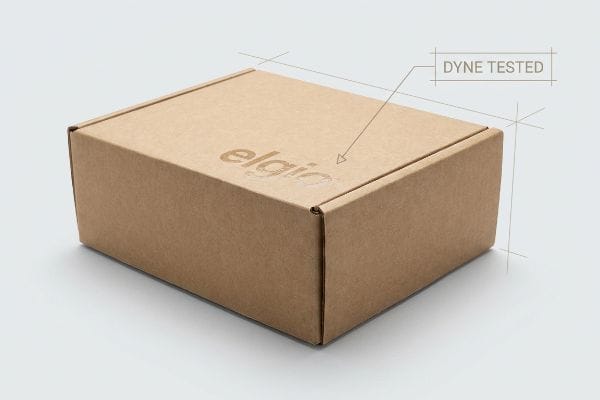 Dyne Tested Cardboard Box Brown corrugated cardboard box featuring a faint "elgia" logo and "Dyne Tested" text, highlighting surface tension quality.